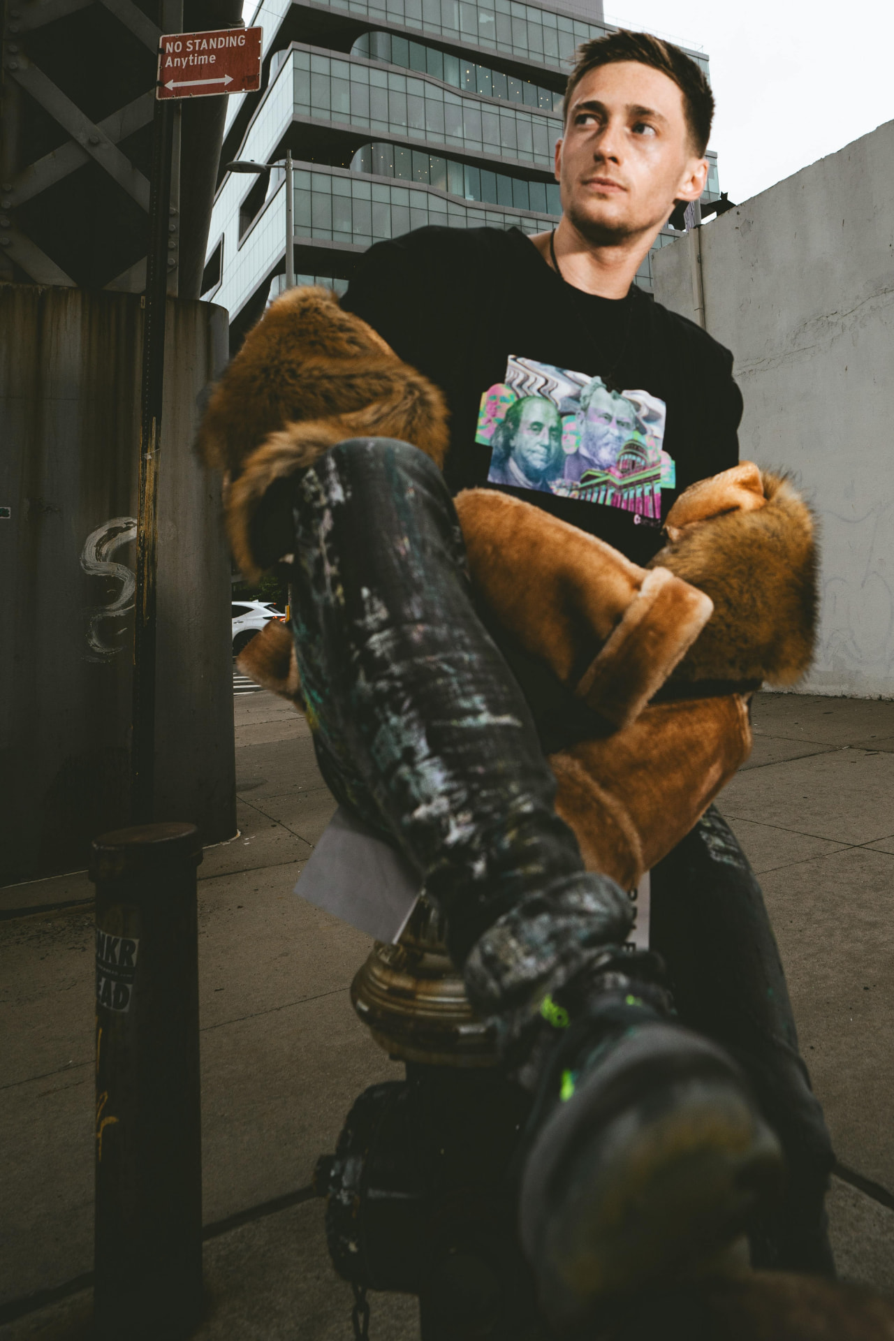 Kaden Quinn kicked back on a Manhattan sidewalk in a fur-collar coat and graphic tee
